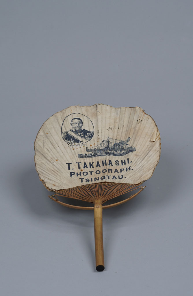 Surviving paper advertising fan with Admiral Tōgō, a warship and the T. Takahashi studio imprint.