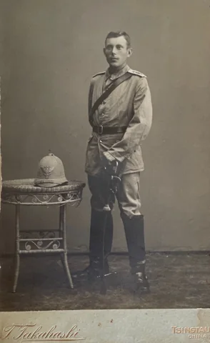 Uniformed Karl Heinrich Wilhelm Hofmann standing beside a table, on a mount with the T. Takahashi imprint.