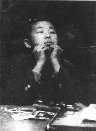 Young Yoshiharu Nakahara resting his chin on his hand.